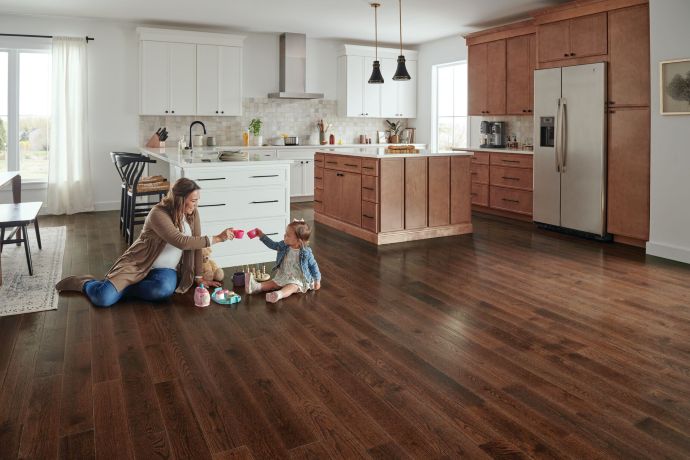 Kitchen with a mother and infant on the floor playing; solid oak hardwood that