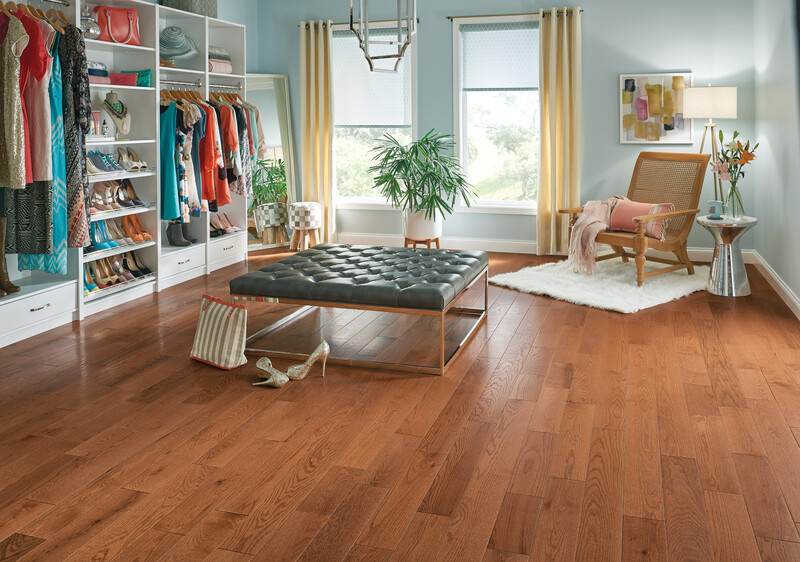 Walk=in closet with a center seating area and white oak flooring